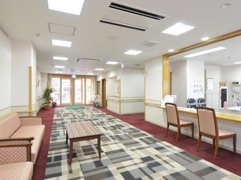 入口は自動ドアになっている。落ち着いた色合いに内部をコーディネートしている。壁には手すりを取り付けている。