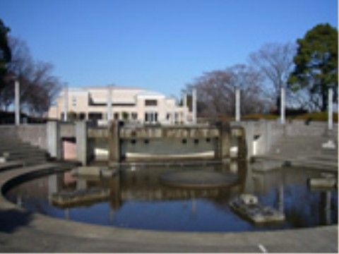緑に囲まれた噴水のある公園。噴水の周りは階段状になっている。お散歩のついでに、日光浴やおしゃべりを楽しむことができる。