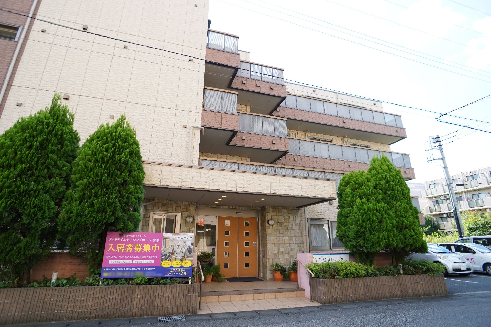 鉄骨造地上４階建ての落ち着いた色調の外観の老人ホーム