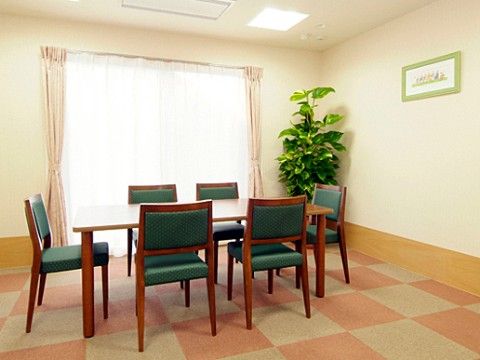 掃き出し窓のすぐ近くに背の高い観葉植物が置かれている談話スペース