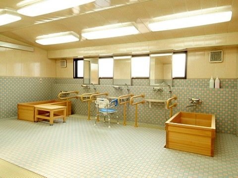 洗い場の水栓は高い位置に設置されており、入居者様は立った状態で腰に負担をかけずに体を洗うことができる。