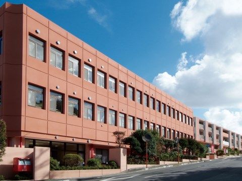 暖色系の外壁が暖かみを感じさせる３階建ての施設外観