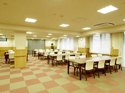 食堂はゆったり広々としていて、市松模様のカーペットが敷かれている。落ち着いた色合いのテーブルと、白い背もたれ付きの椅子が設置されている。