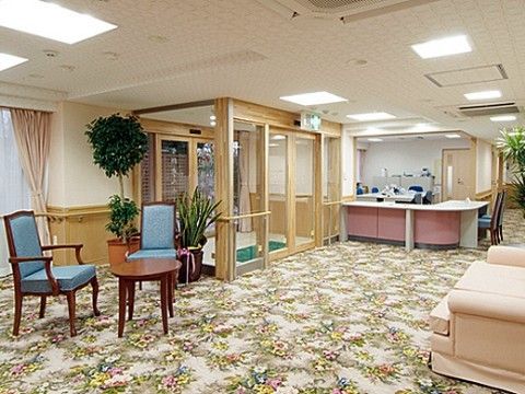背もたれのある椅子やローテーブルが置かれたエントランス