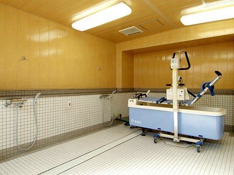 清掃の行き届いた清潔で明るい浴室には、リフトに寝た姿勢で入浴することができる介護用の浴槽が置かれている。