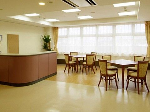 落ち着いた雰囲気のテーブルセットが置かれ、とても明るい空間になっている。左手にはスタッフルームのカウンターがある。