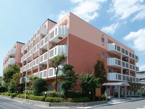 居室バルコニーの白色の壁が印象的で、一部が５階建てになっている施設建物