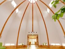 ドーム型で天井が高い施設内の天井空間。温かい日差しが差し込む場所