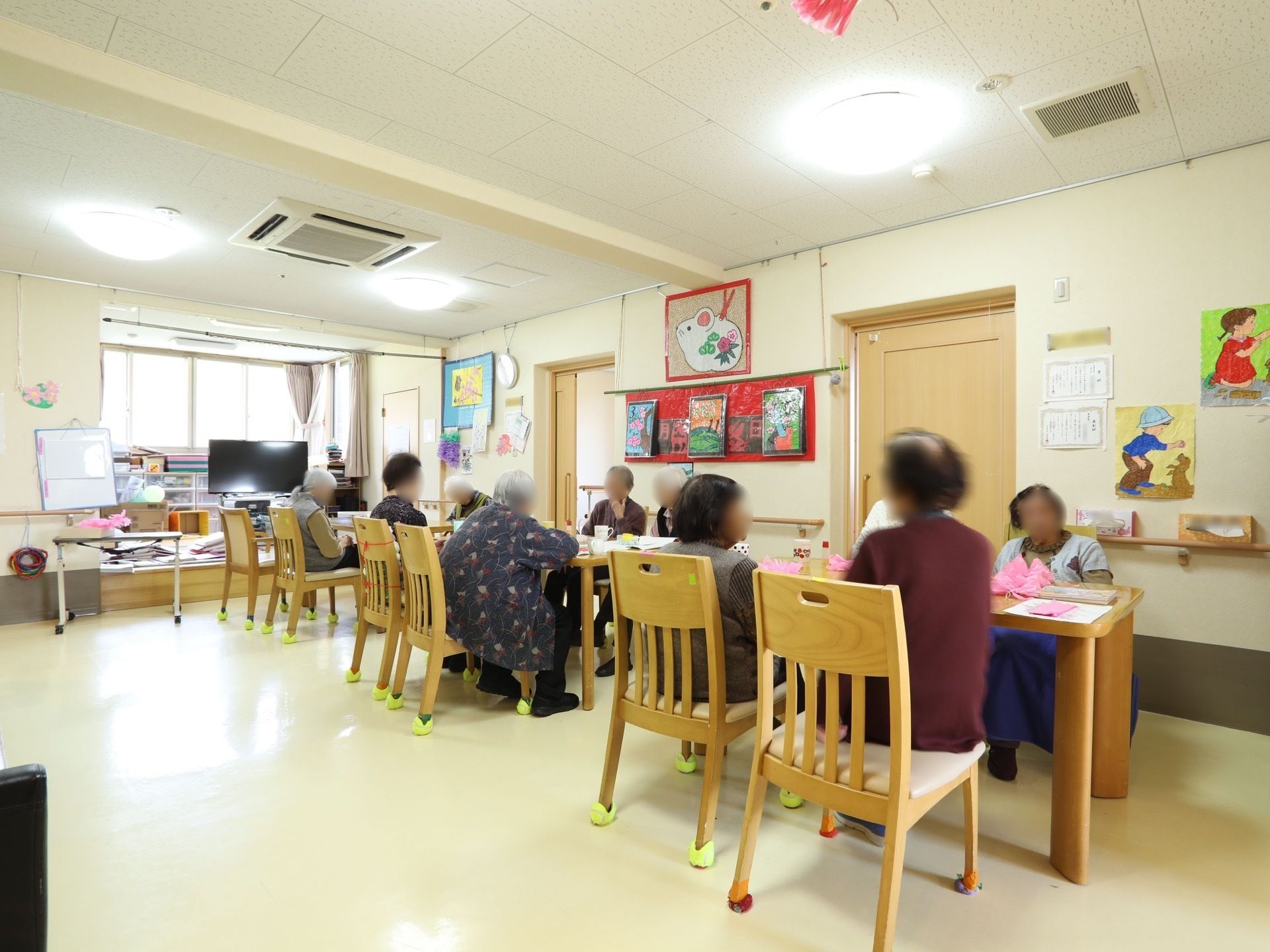 入居者が椅子に座って団らんしている賑やかなダイニングルーム
