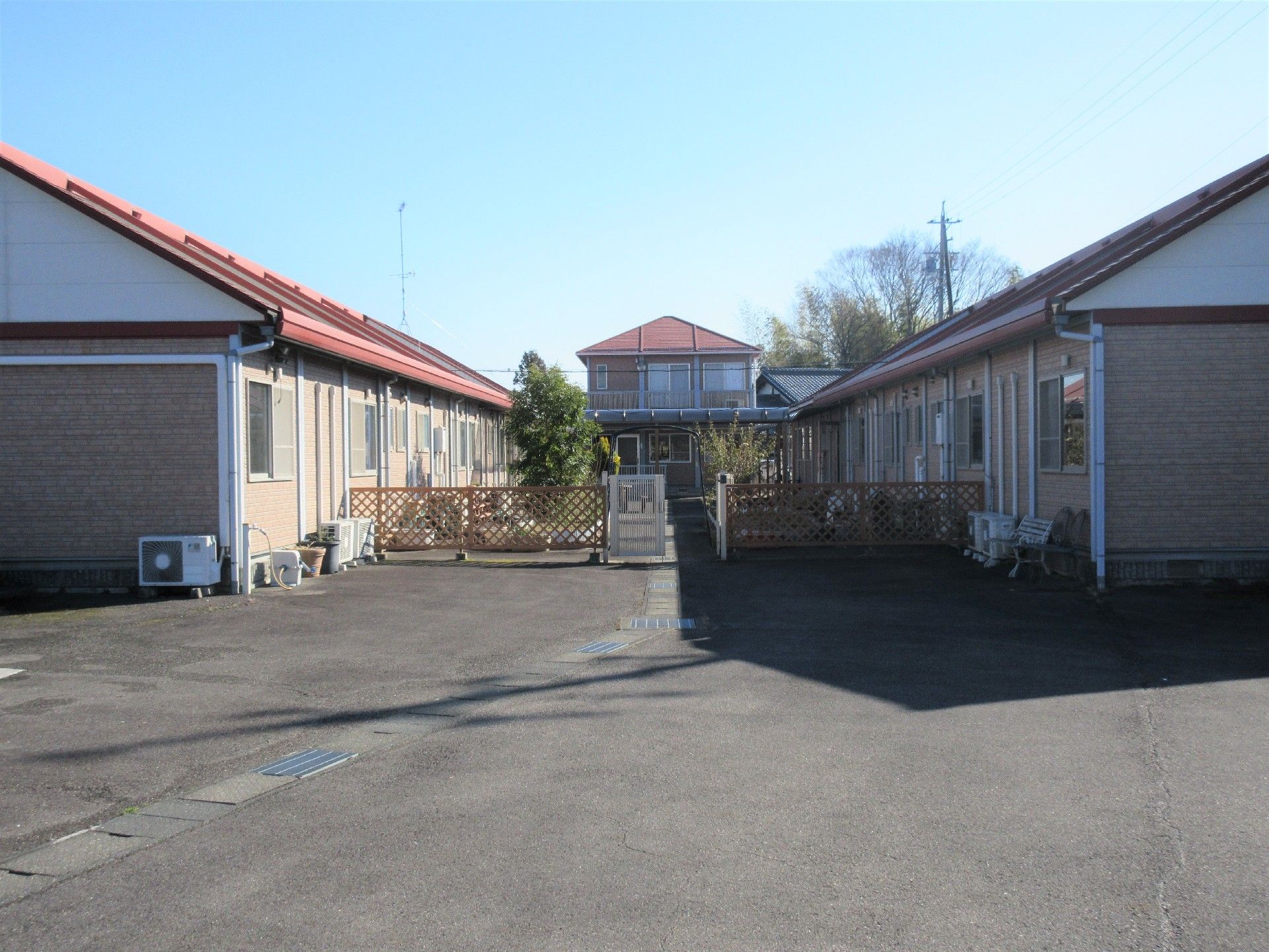 広めの敷地内にいくつかの建物が建っている様子。平屋建ての建物の様子