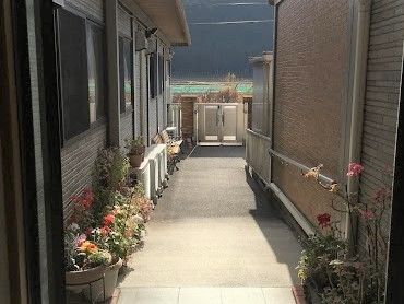 施設の外側にある廊下の様子。両側に花が植えられているのがわかる