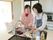 キッチンで楽しそうに皿洗いをしている女性入居者と女性スタッフ。