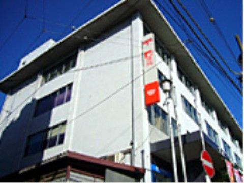 施設の近所には大きめの郵便局があり、窓がたくさん取りつけられている。入口には、屋根も設置されている。