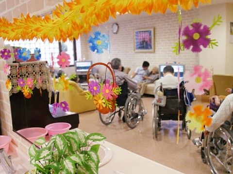 色鮮やかな創作品で飾られた休憩スペースに集まっている入居者様たち