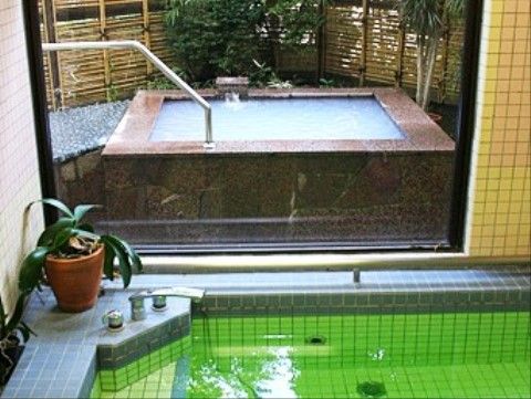 浴槽には緑色のお湯がはられており、全面タイル張りになっている。窓からは、露天風呂を望むことができる。