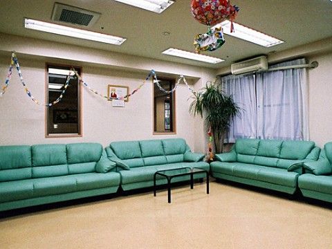 ３人掛けの緑色のソファが並べて置かれている休憩スペース