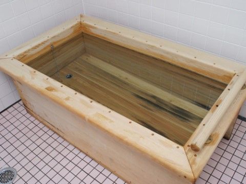 丈夫な木材で作られた浴槽が設置されている。縁が広く、手前の端には手すりも付いており、ゆっくりとご入浴いただける。