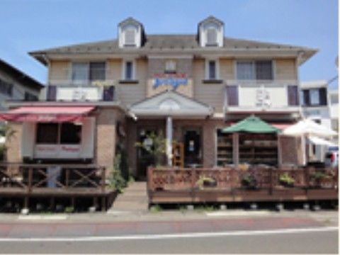 店舗の外観である。左右対象の洋館風な建物で、建物の前はラティスフェンスで囲まれたテラスになっている。