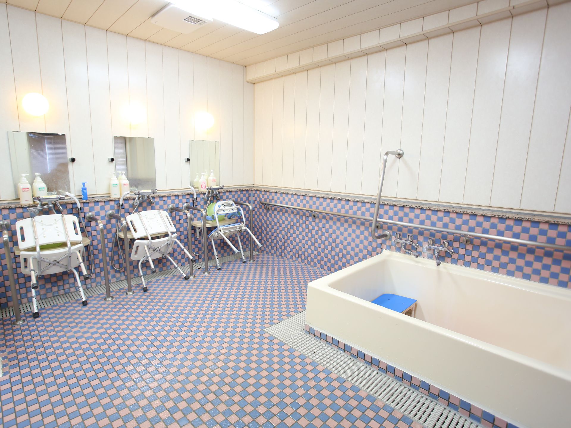 バリアフリー完備で手すりが取り付けられ、滑りにくい床材が使われている浴室