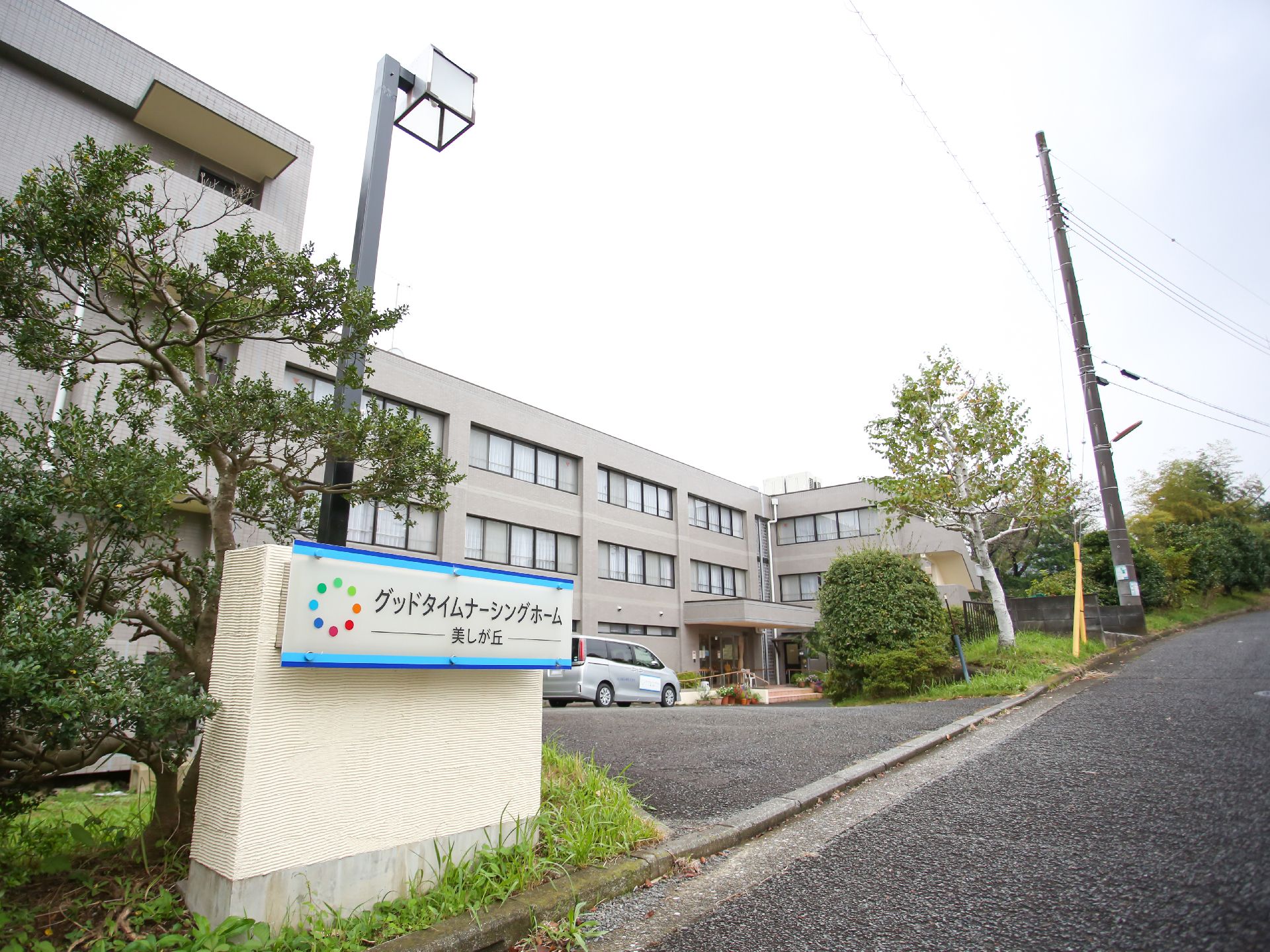 広い駐車場と看板が設置されている介護施設