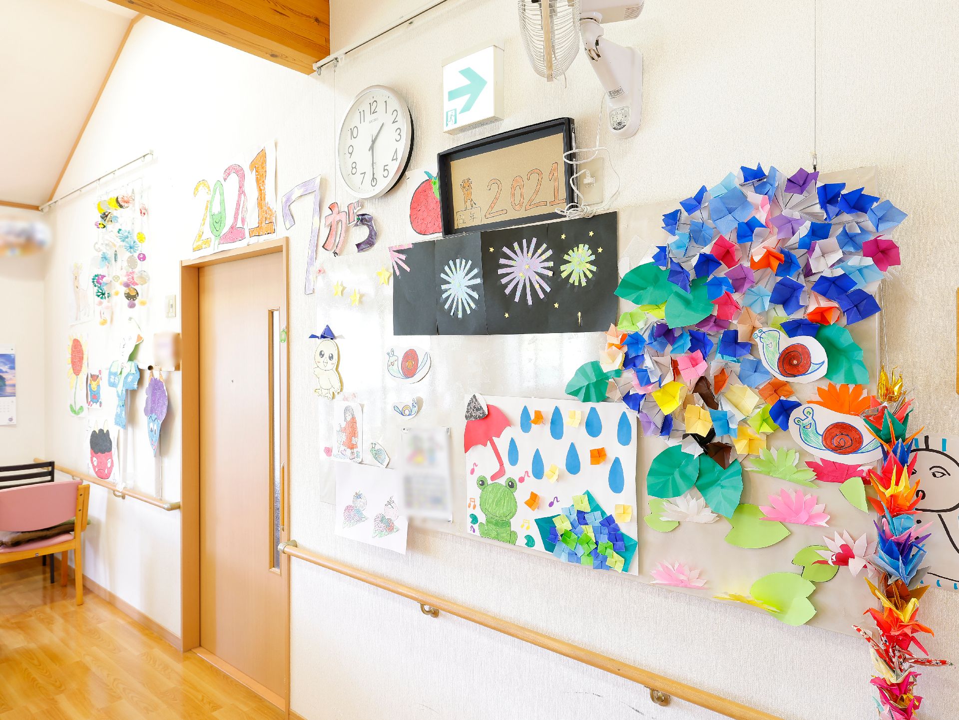 壁一面に貼り付けられている、折り紙などを使った色とりどりの展示物