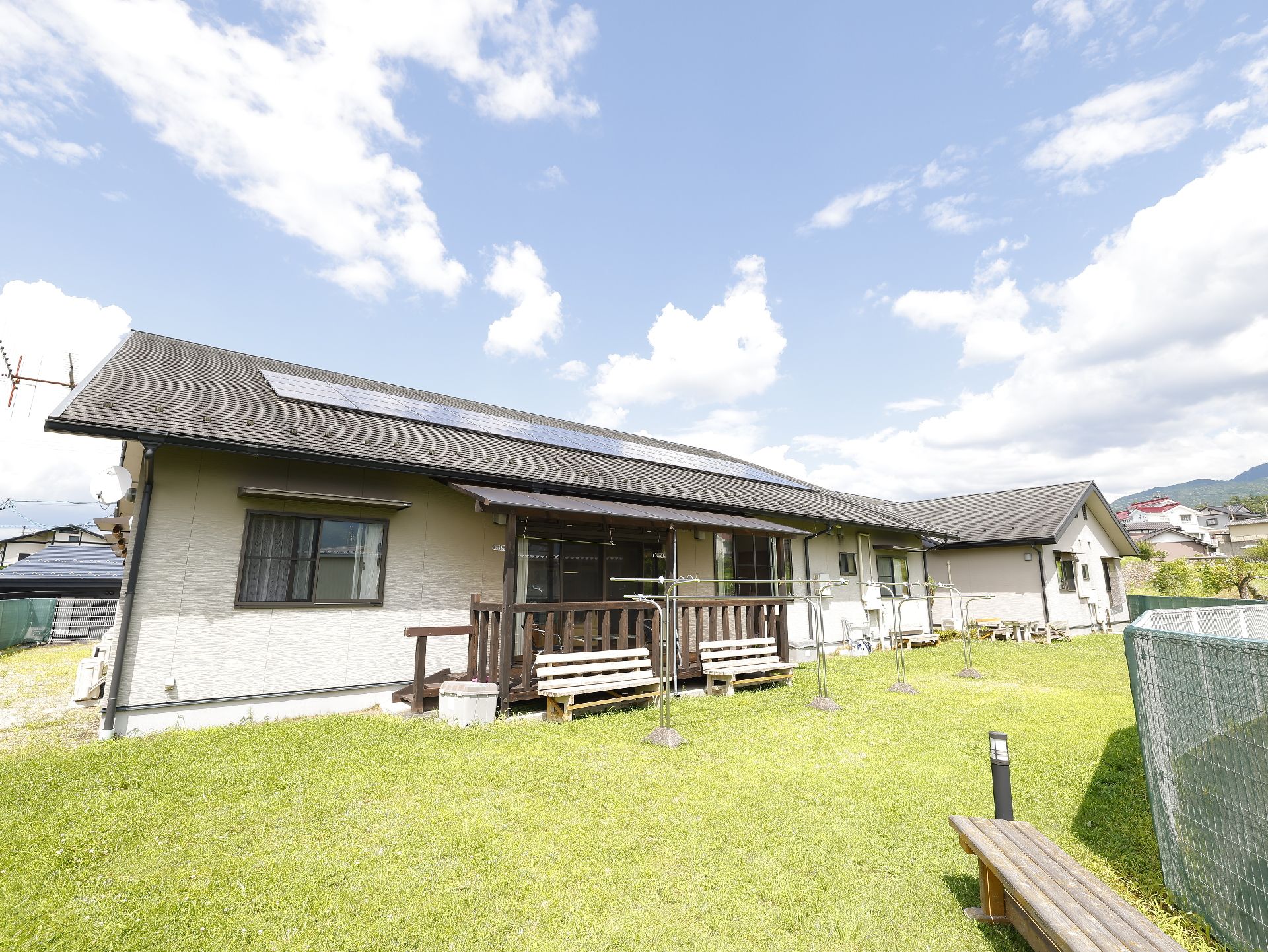 芝生が敷かれ、散歩途中に休憩できるベンチがある施設の中庭