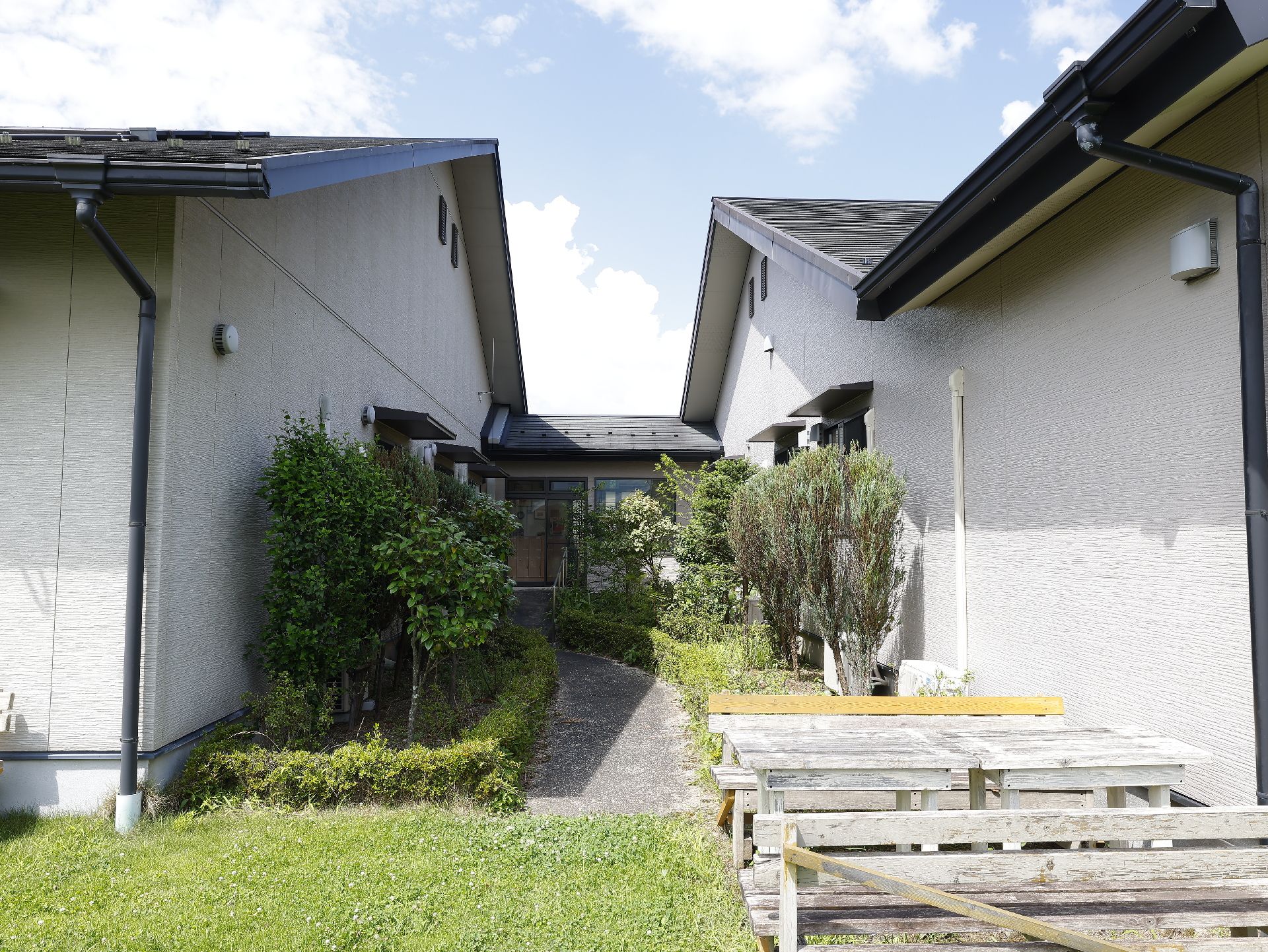 館内から中庭に通じ、両側に木々が植えられている散歩道