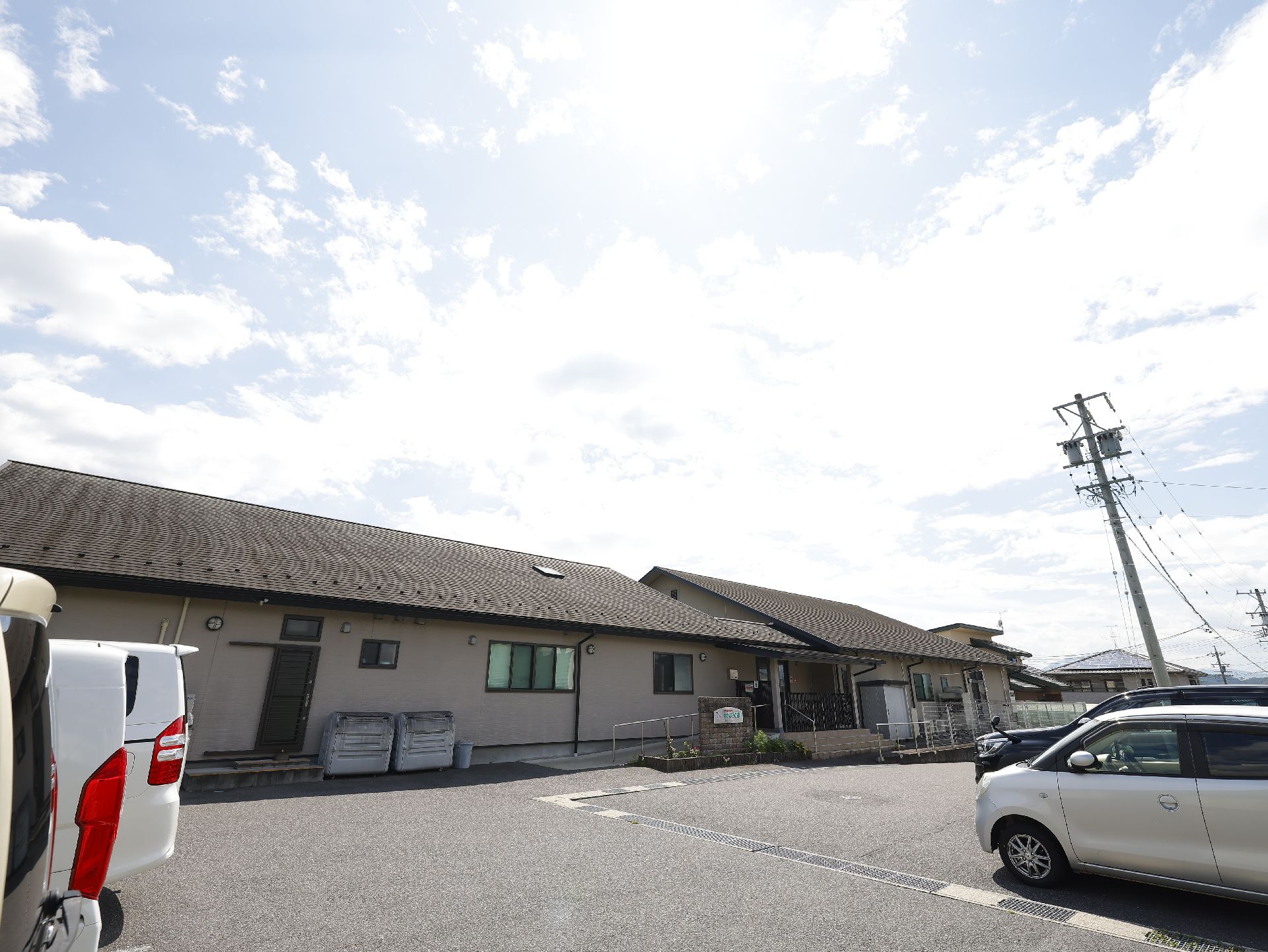 施設の建物の前にアスファルトで整備されている駐車場