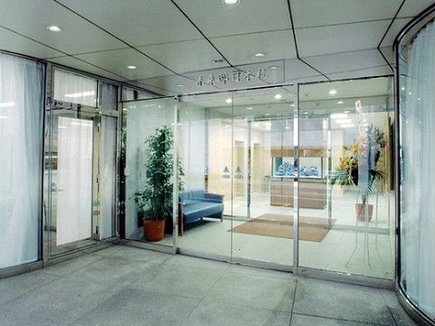 入り口は二重の広い自動ドアで全面ガラス張りになっているため見通しが良い。観葉植物やソファーが置かれている。