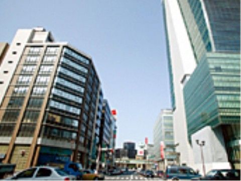 高層ビルがそびえ立つ活気ある街並。道路には車が行き交う。洗練された都会的でエネルギッシュな雰囲気を満喫できる。