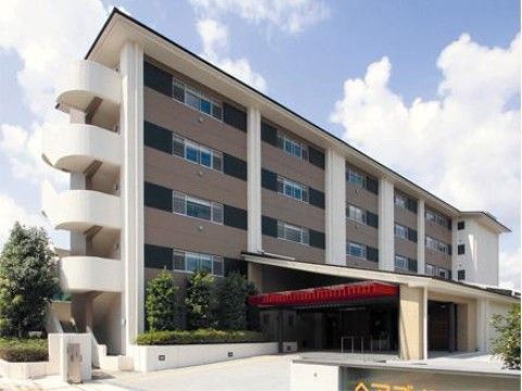 斜め状の大きな屋根がついた車寄せがある施設の玄関付近