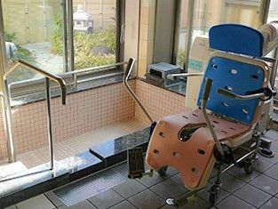 浴槽はタイル張りで手すり付きの階段が付いていて、窓の外には中庭がある。リフトも付いている。