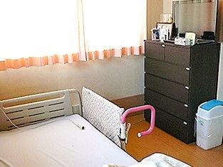 レースカーテンが付いた窓がある部屋には寝具付きのベッドが置かれ、タンスもある。