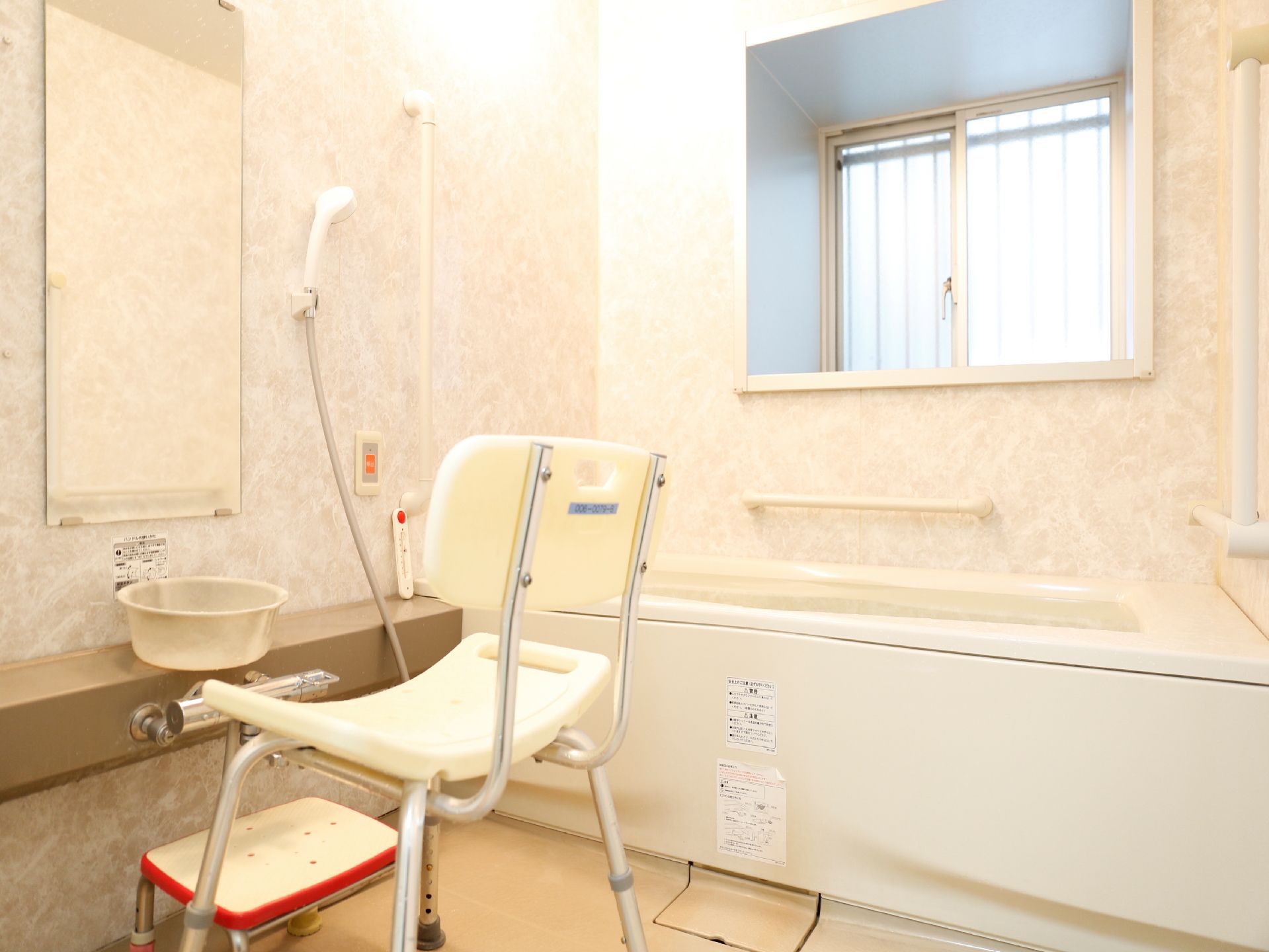 個室のお風呂には窓がある。鏡の前には介護用お風呂椅子も置かれているので、高齢者の身体の負担が軽減される。