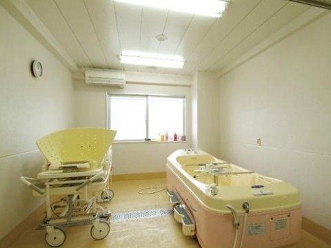 窓や照明により明るい空間となっている。横になったままでも入浴することができる介護浴槽が設置されている。