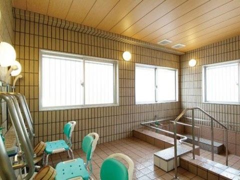 浴室の２面は窓になっている。広々とした浴槽には手すりが取り付けられている。シャワー台がいくつも設けられている。