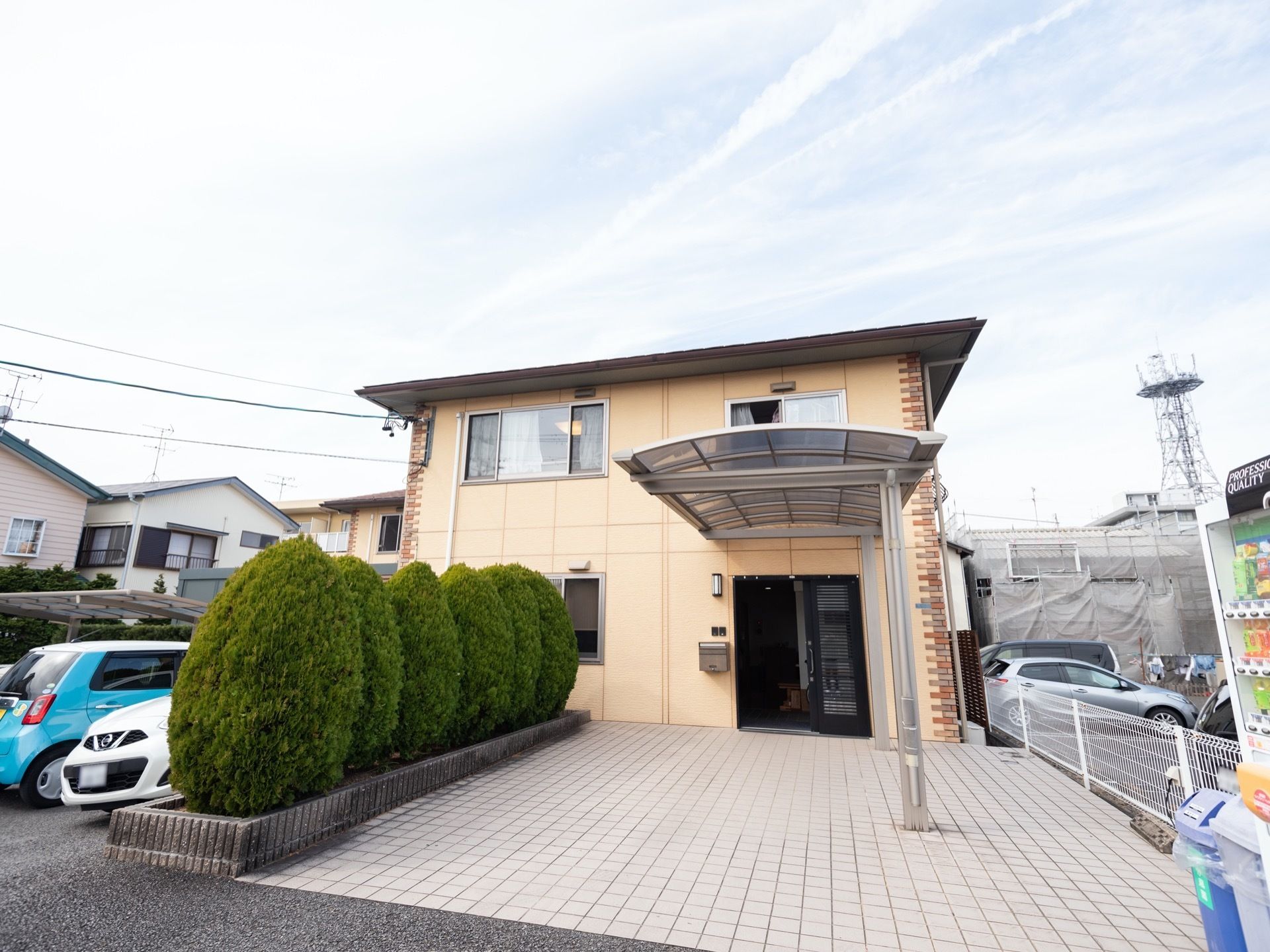 オレンジ色の二階建ての施設である。玄関周りには手入れされた庭木が並び、大きな雨避けが設置されている。