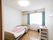 部屋には大きな窓が付いており、屋外の明るい光が差し込んでいる。壁には、洋服などを掛けられるフックが取り付けられている。