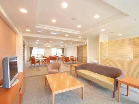 壁際の棚に上にテレビがあり、そちらを向いてソファが置かれている休憩スペース