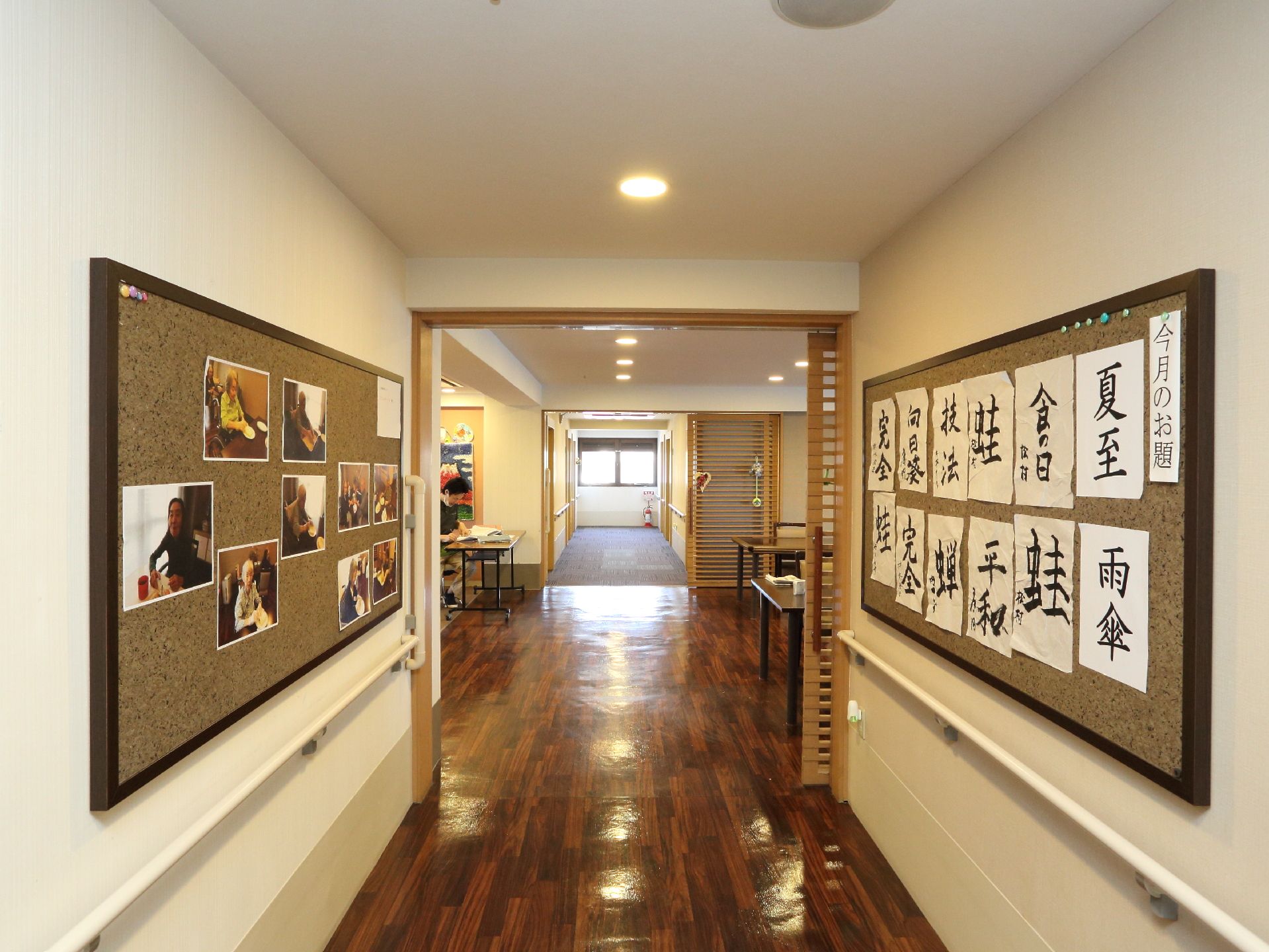 廊下部分の白い壁に、入居している方の写真や書道の作品が飾られていてギャラリーのようなモダンな雰囲気になっている。