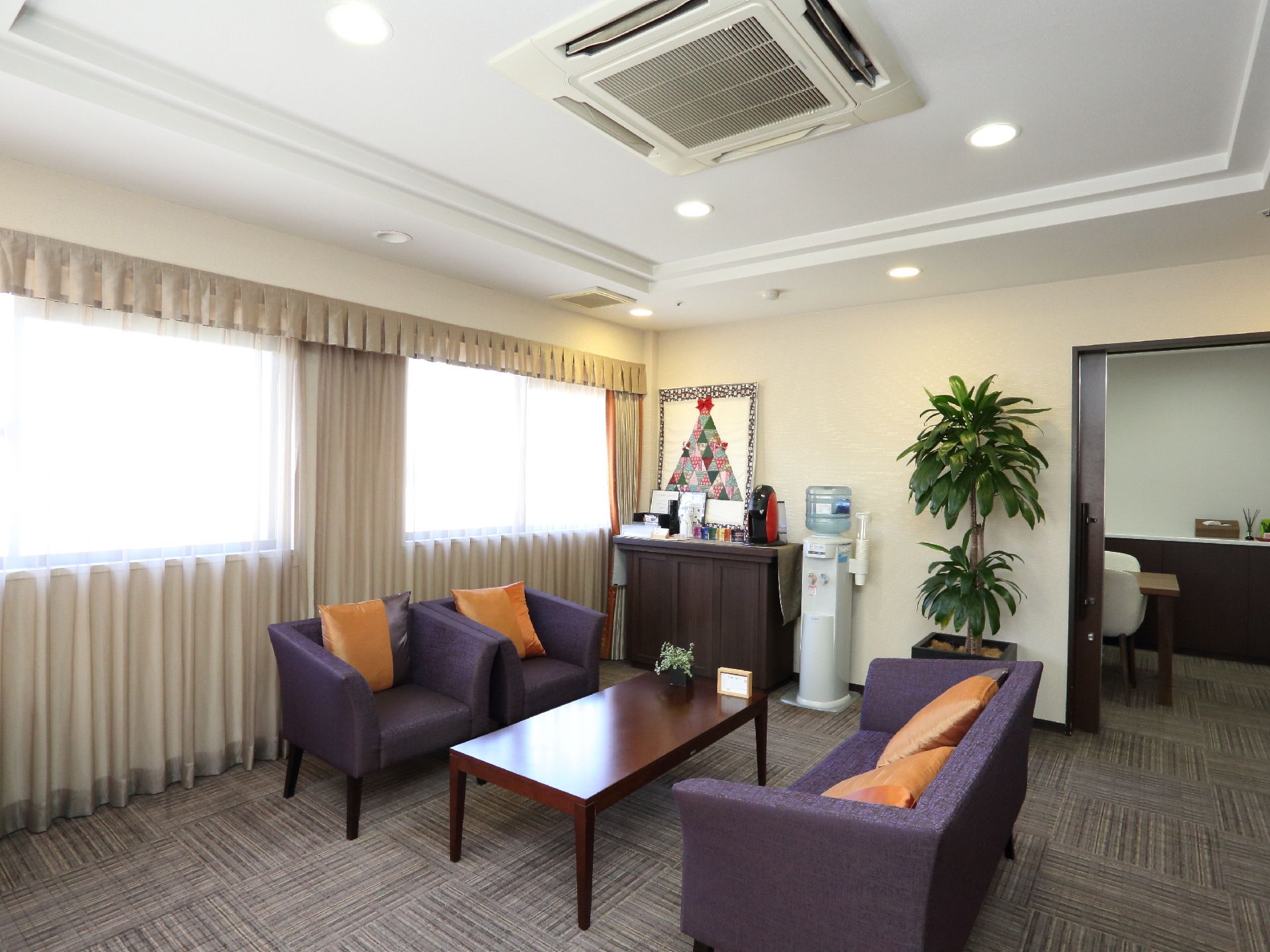 窓から日の光が入る落ち着いた雰囲気の部屋で、ソファに座って会話を楽しむことができるスペースである。ウォーターサーバーもあり便利になっている。