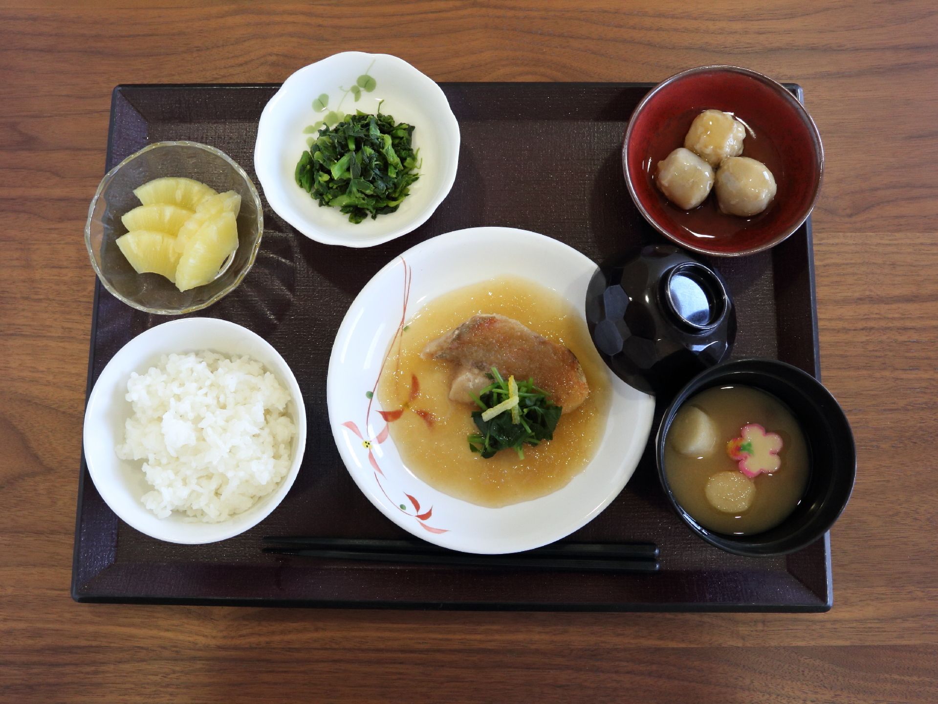 和食中心で、食べやすい大きさに切った野菜をふんだんに使った食事を提供している。デザート付き。味噌汁の椀には蓋がついている。