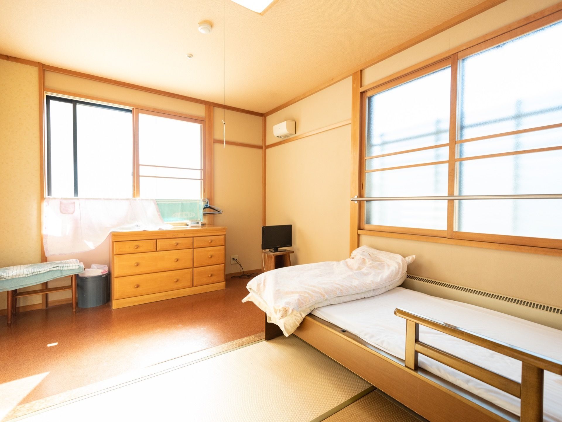 日当たりが良い個室である。ベッドが設置されており、布団が用意されている。収納棚ががある。