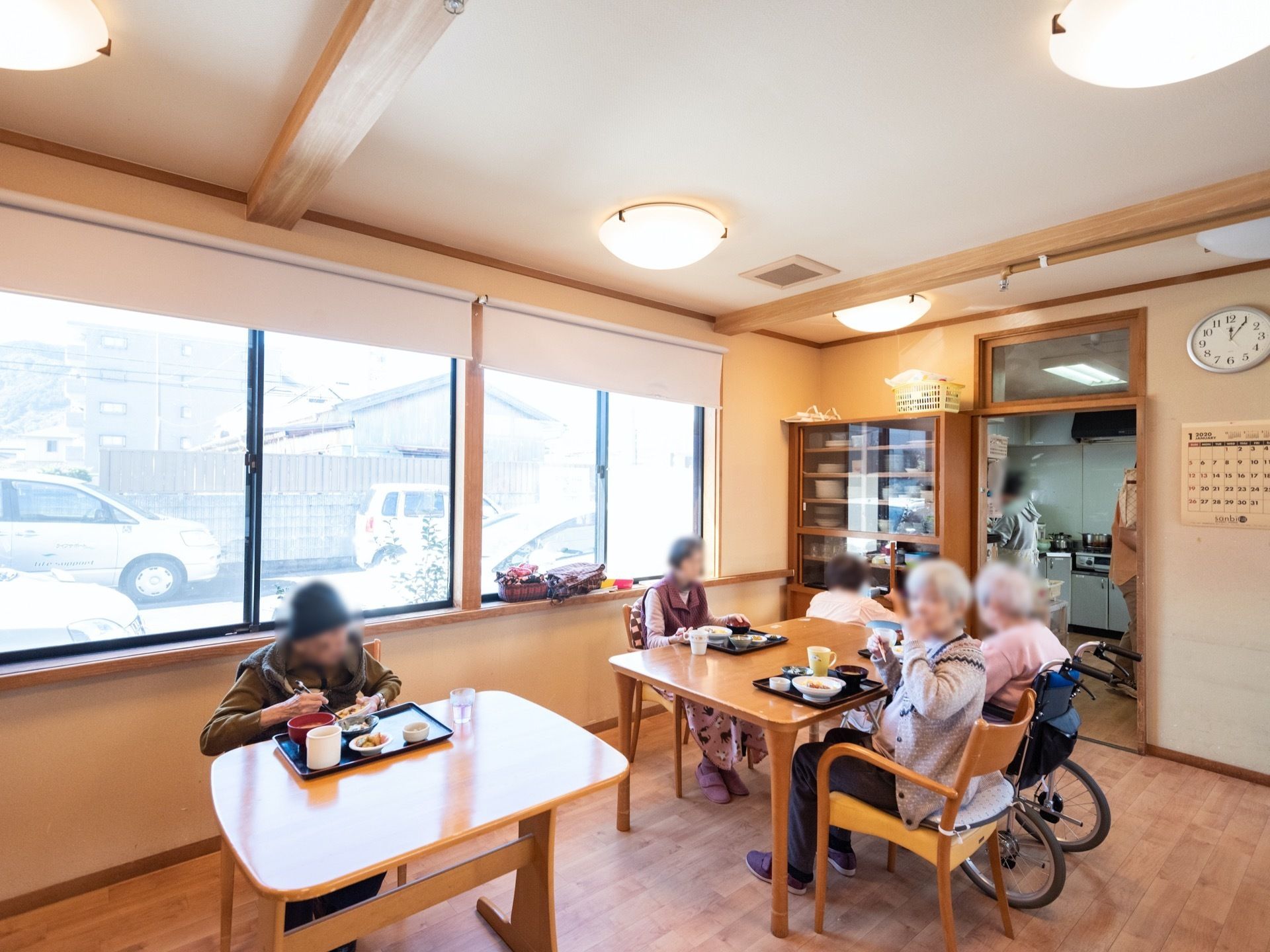 キッチンが併設された食堂。ダイニングテーブルが数台設置されており、入居者様が集まり食事を楽しんでいる。