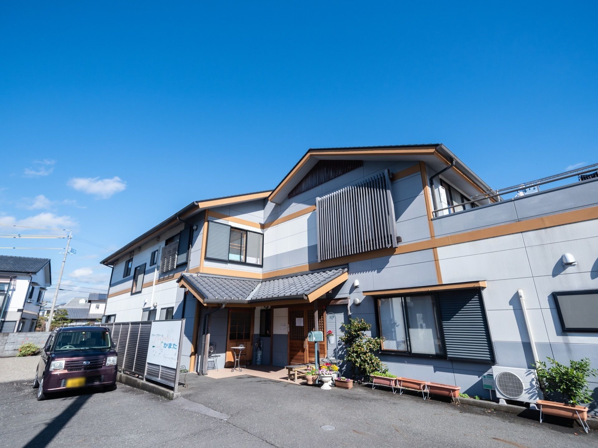 三角屋根が付いた和風の建物は大きな一軒家のようなイメージ。駐車スペースもあり、玄関には屋根も付いている。