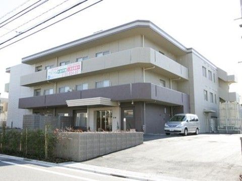 道路から一段高い敷地に建っている３階建ての施設外観