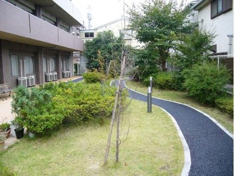 施設敷地内にある、カーブした散策道とその周辺の植栽