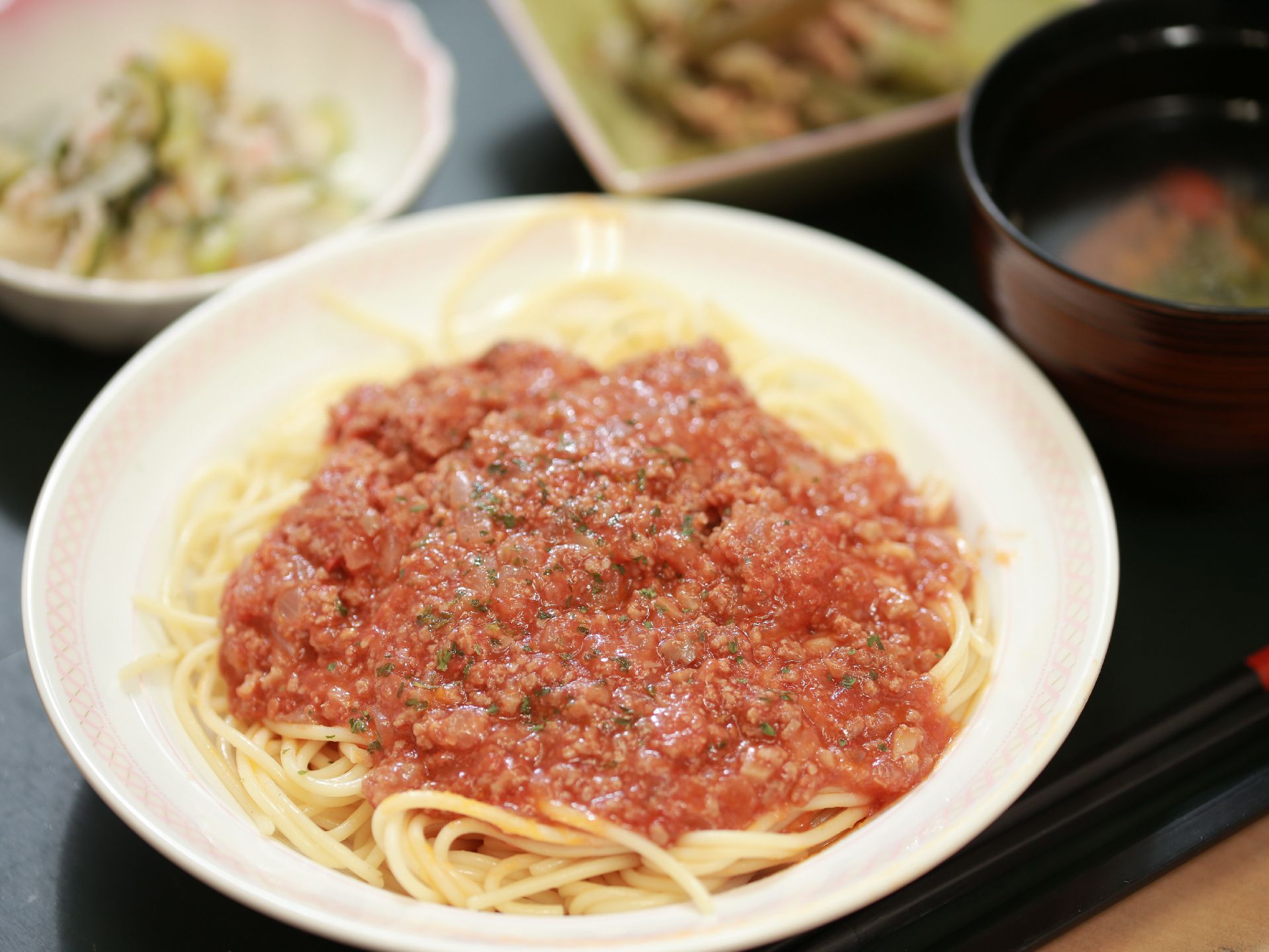 ミートソースのパスタや小鉢が載っているお食事のプレート