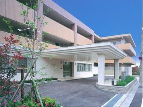 白色の太い柱がある、玄関前に大きく張り出した車寄せ