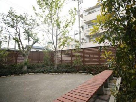 背の高いウッドフェンスで目隠しされている施設内の庭園